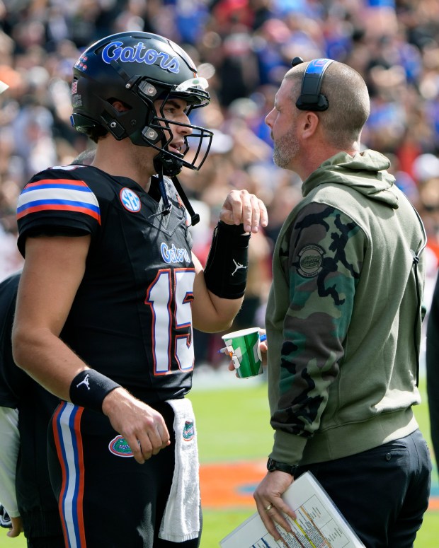 Florida head coach Billy Napier, right, talks with quarterback Graham Mertz during the Gators' loss to Arkansas Nov. 4 in Gainesville. (AP Photo/John Raoux)