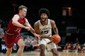 Miami forward Norchad Omier (15) looks for a play under pressure from New Jersey Institute of Technology forward Kjell de Graaf (33) during the second half of an NCAA college basketball game, Monday, Nov. 6, 2023, in Coral Gables, Fla. (AP Photo/Rebecca Blackwell)